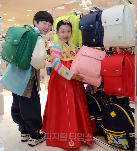 설을 앞두고 서울 소공동 롯데백화점 본점 휠라 키즈매장에서 아역스타 길정우, 김하유가 설 선물로 DIY 스티커를 이용한꾸민 비엘라 책가방을 선보이고 있다.  휠라코리아 제공